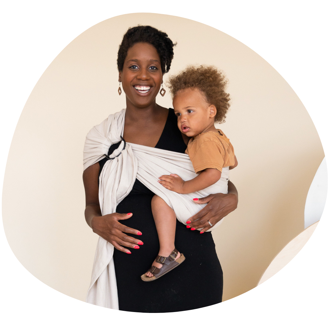 Black woman babywearing her toddler in a hope&plum lark while pregnant