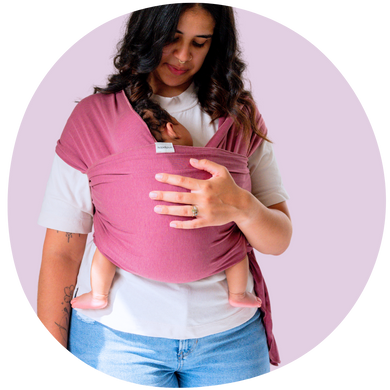 Mother holding her newborn baby in a rose colored baby wrap carrier
