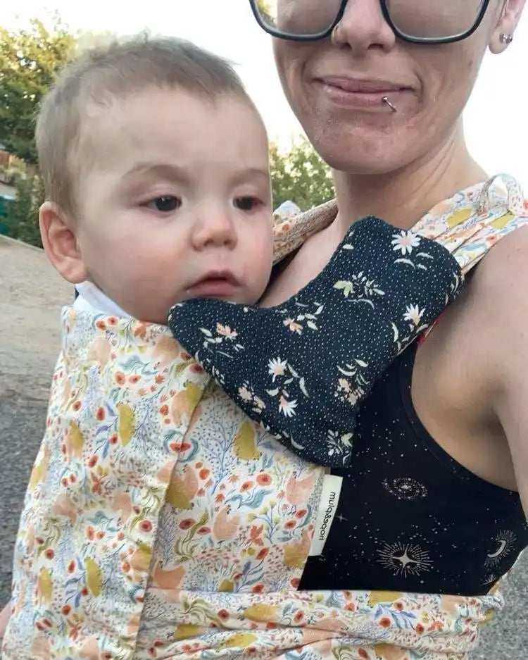 Baby in floral carrier.