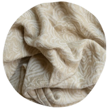 Fabric close up showing cream colored ring sling with topography design. 