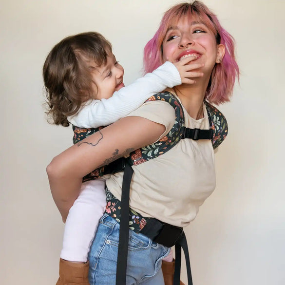 Floral baby carrier with child.