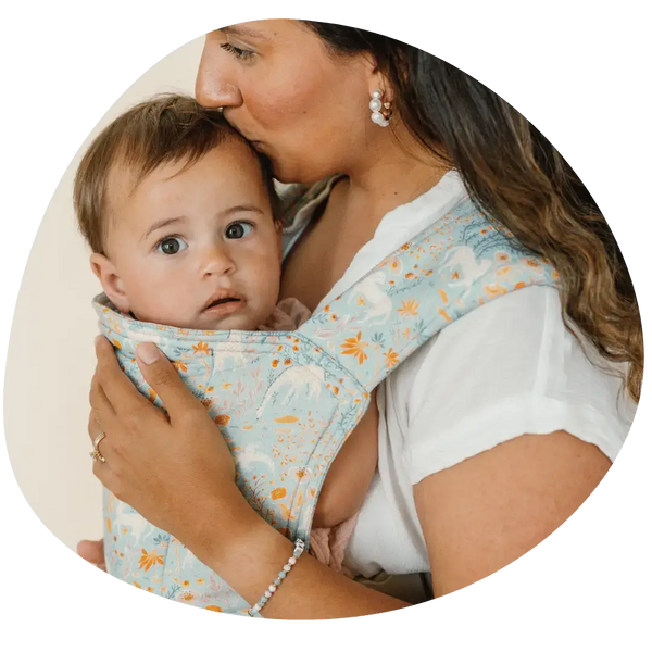 A woman wearing her baby in a hope&plum lark baby carrier