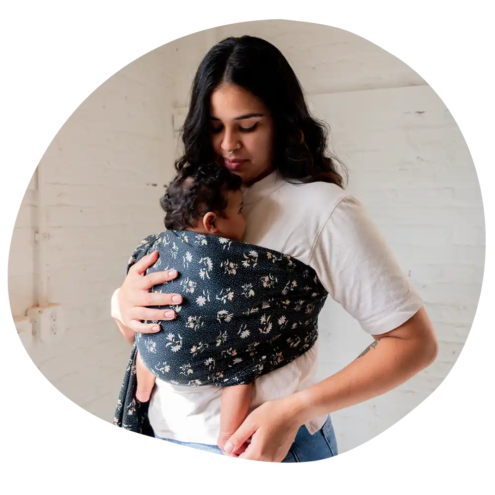 Mother carrying baby in floral sling.