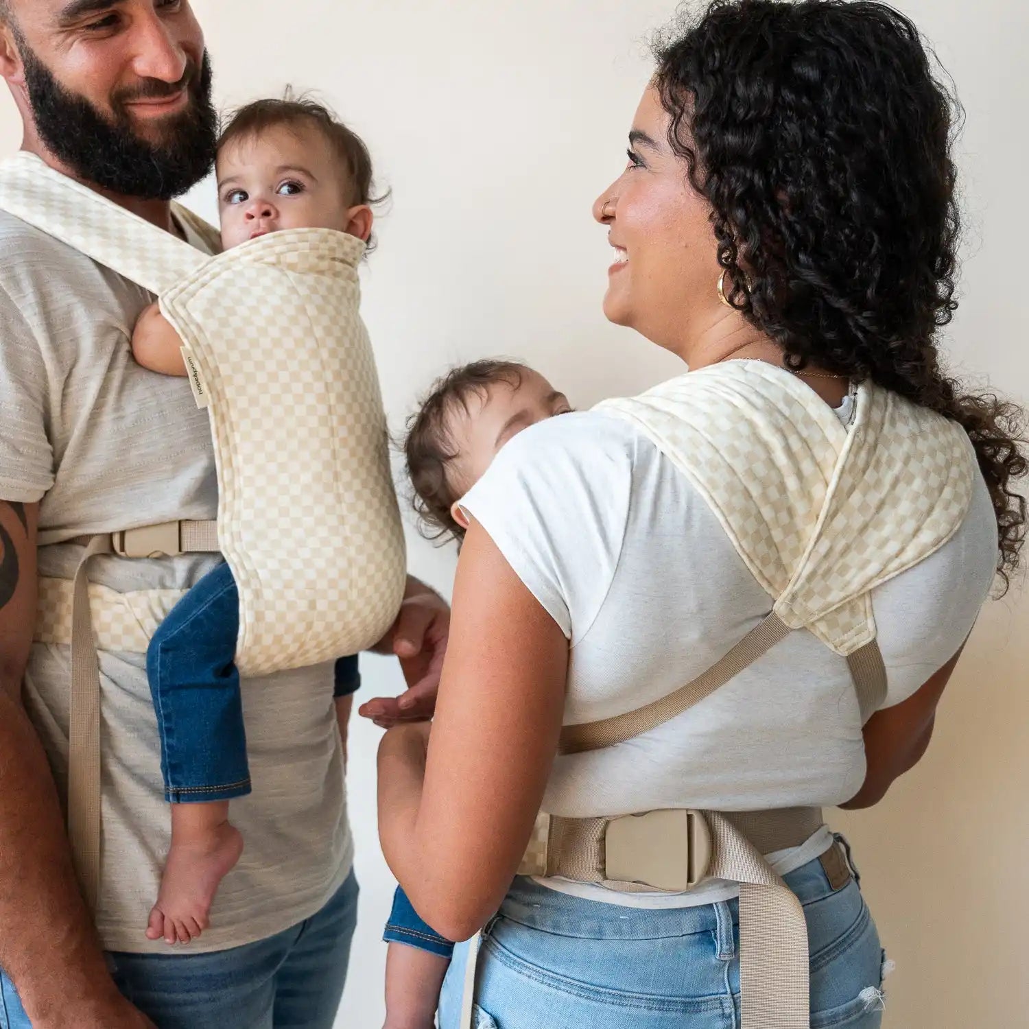 Parents wearing babies in carriers.