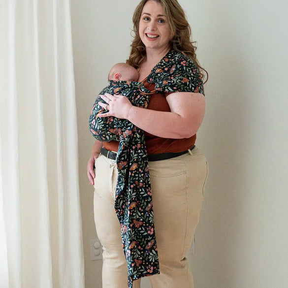 Woman carrying baby in floral sling.